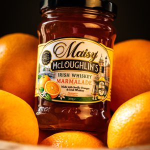 Jar of Maisy McLoughlin's Irish Whiskey Marmalade in a bowl of oranges