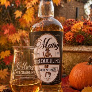 Maisy McLoughlin's engraved Túath glass with a bottle of Maisy McLoughlin's Irish Whiskey